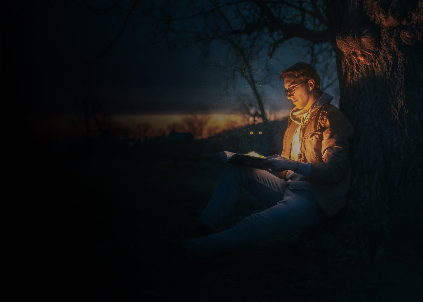 Person reading a glowing book under a tree at night, surrounded by a peaceful twilight landscape.