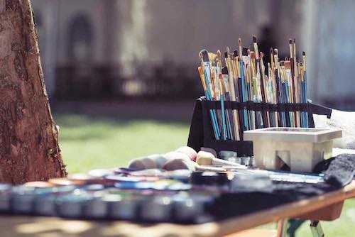 A collection of artist paintbrushes set outdoors, capturing creativity and artistic tools in natural light for plein air painting.